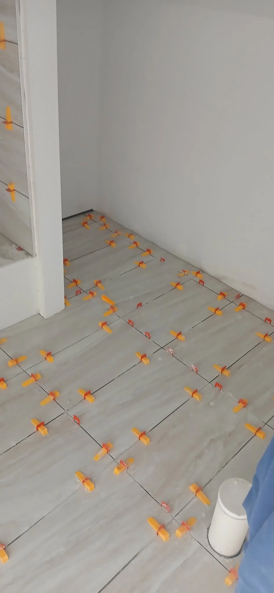 Bathroom floor tile being installed with leveling clips
